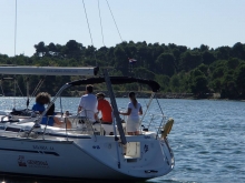 Zdjęcie rufy odpływającego jachtu wraz z załogą   podczas kursu na jachtowego sternika morskiego w Chorwacji foto: charter.edu.pl